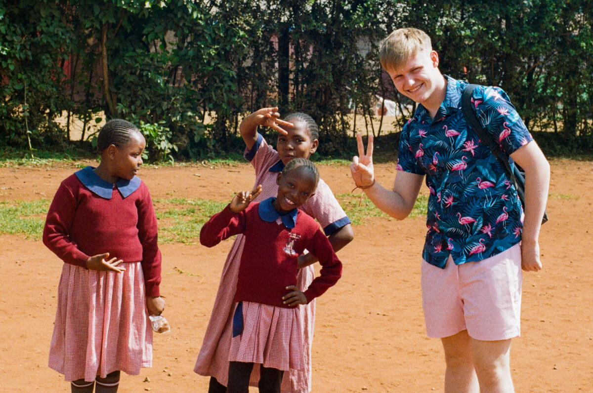 Sean standing with school children