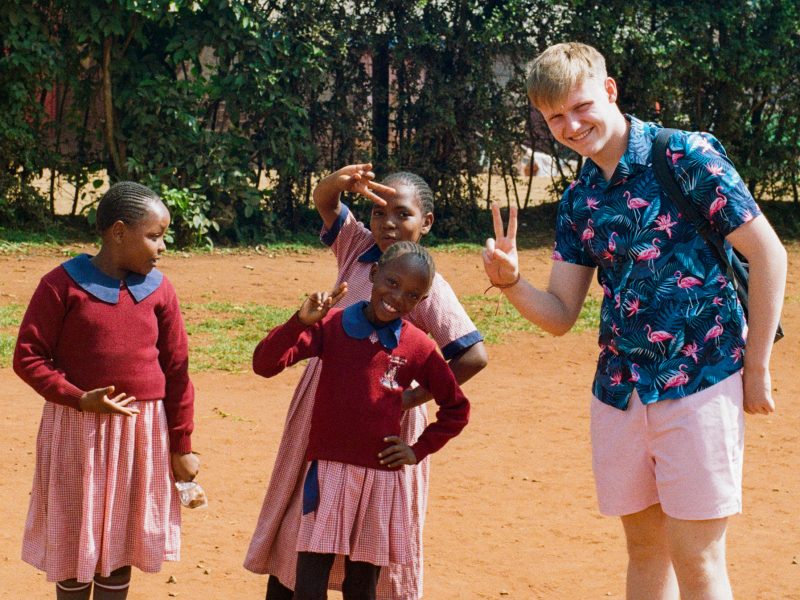 Sean standing with school children